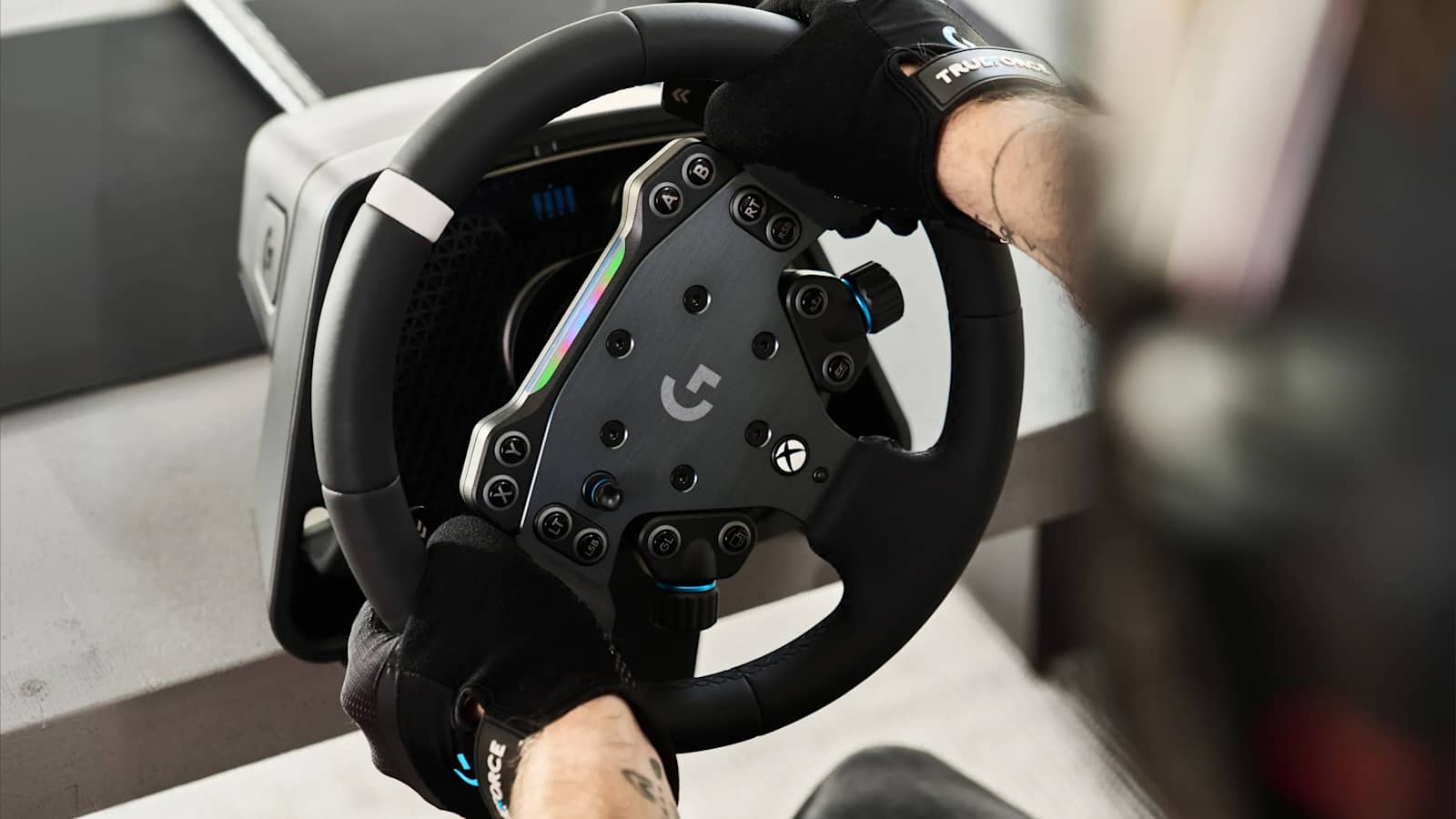 Two hands in black sim racing gloves holding a Logitech G direct drive wheel