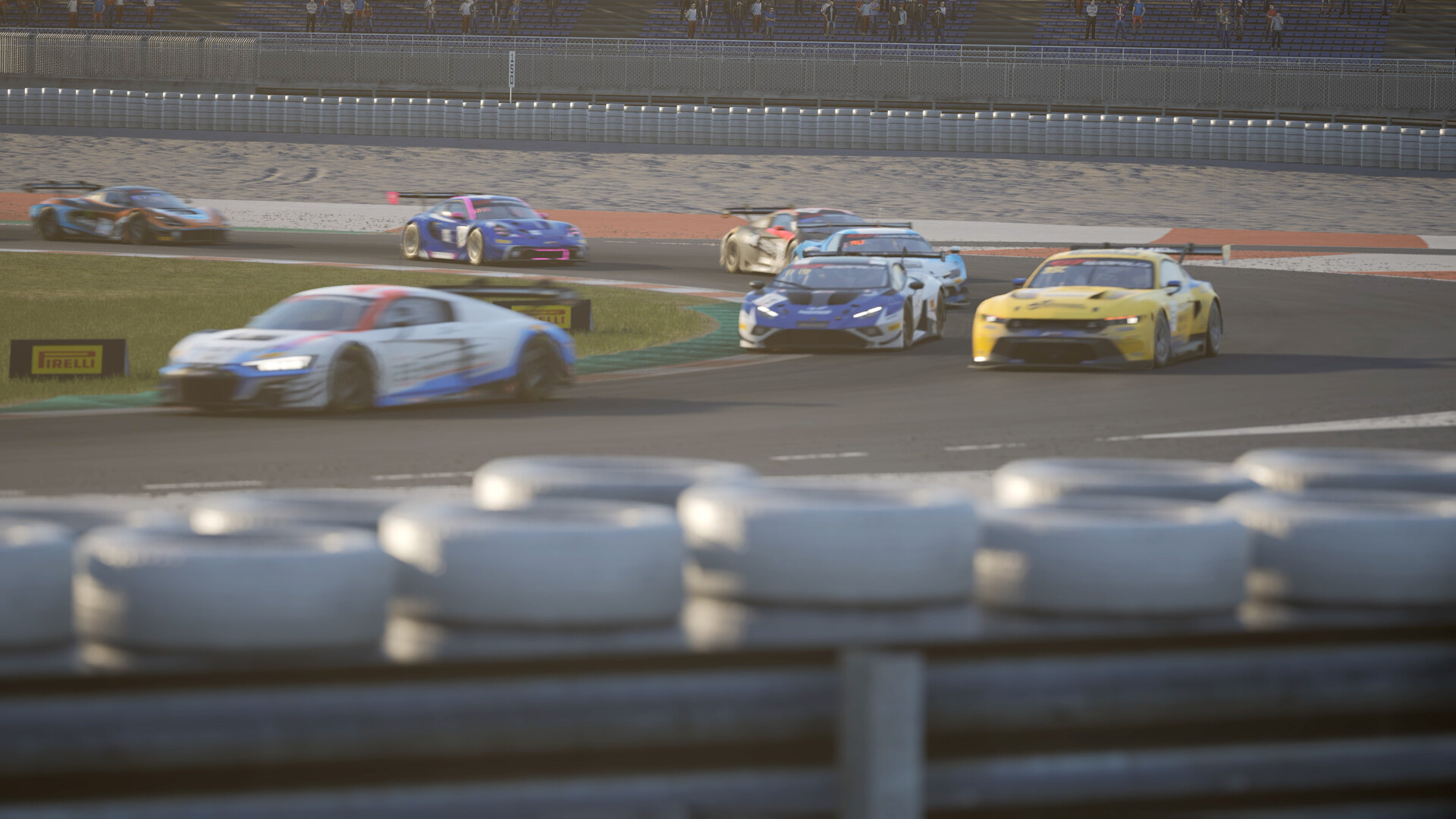 GT3 cars including an Audi R8, a Ford Mustang and a Lamborghini Huracan race through a corner behind a tyre wall in Assetto Corsa Competizione