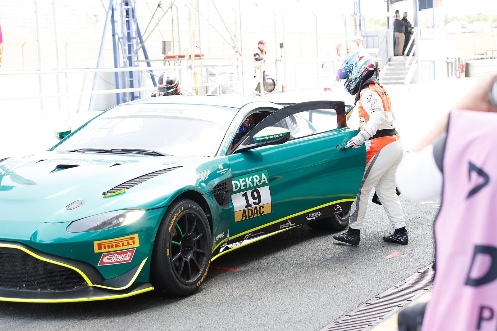 A driver getting into an Aston Martin GT4 car during a pit stop