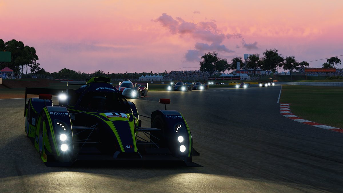 A prototype with its headlights on leads a field of cars at dusk in Automobilista 2