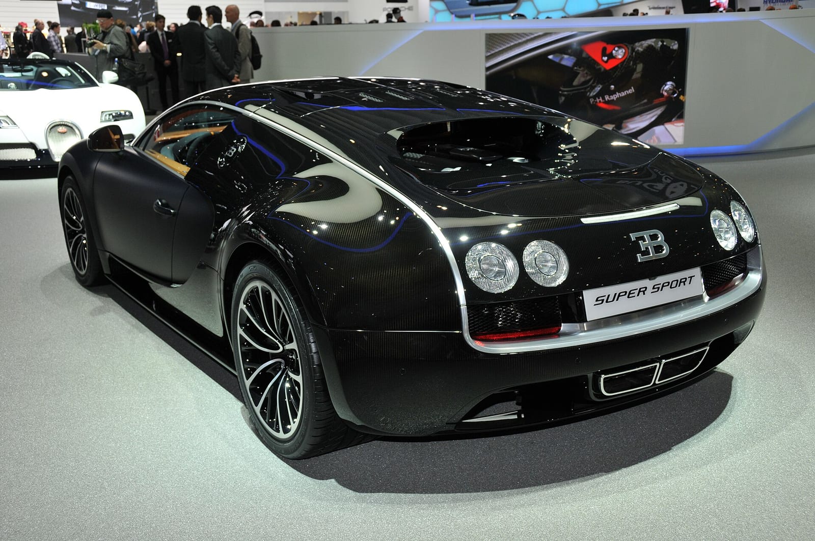 A black Bugatti Veyron Super Sport on a motor show stand
