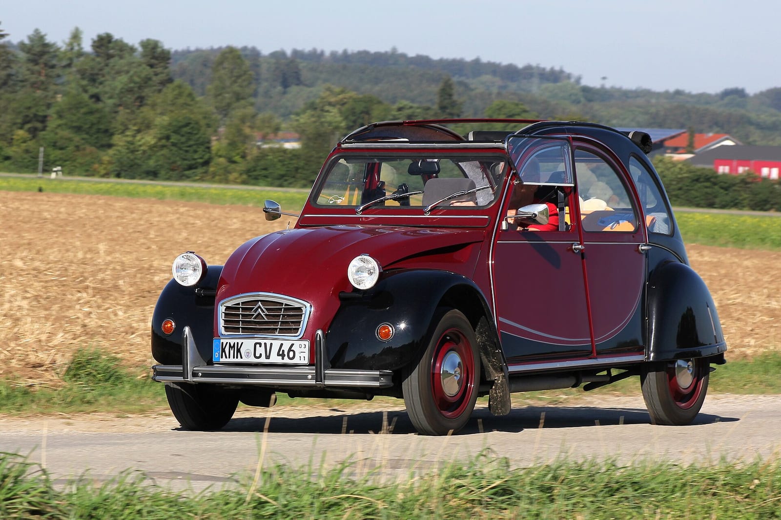 Dark red and black Citroen 2CV Charleston driving on a country road