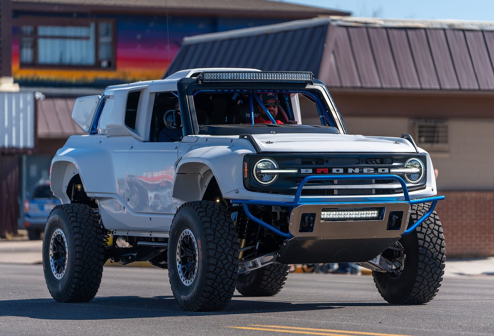A lifted Ford Bronco with a roll cage, light bar and large off-road tyres