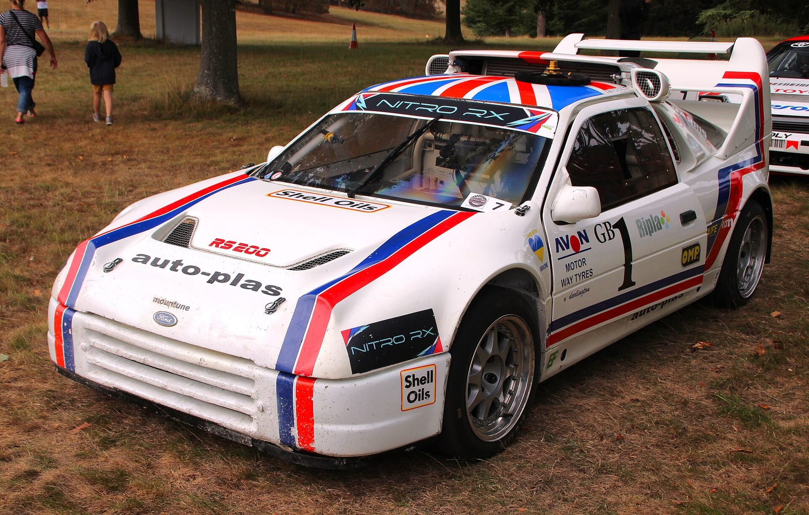 A white Ford RS200 Evolution rallycross car with red and blue stripes