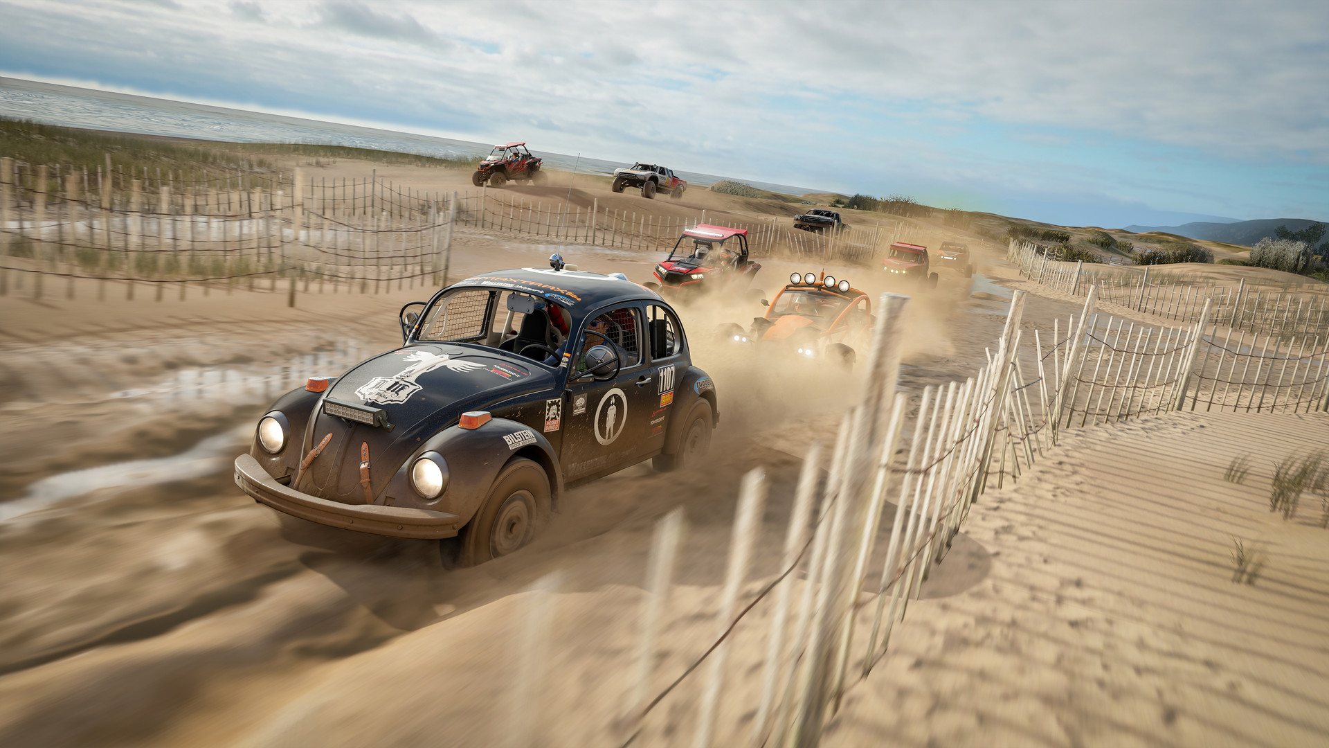 A rally Beetle leads a pack of buggies through sand dunes in Forza Horizon 4, seen from a chase camera angle