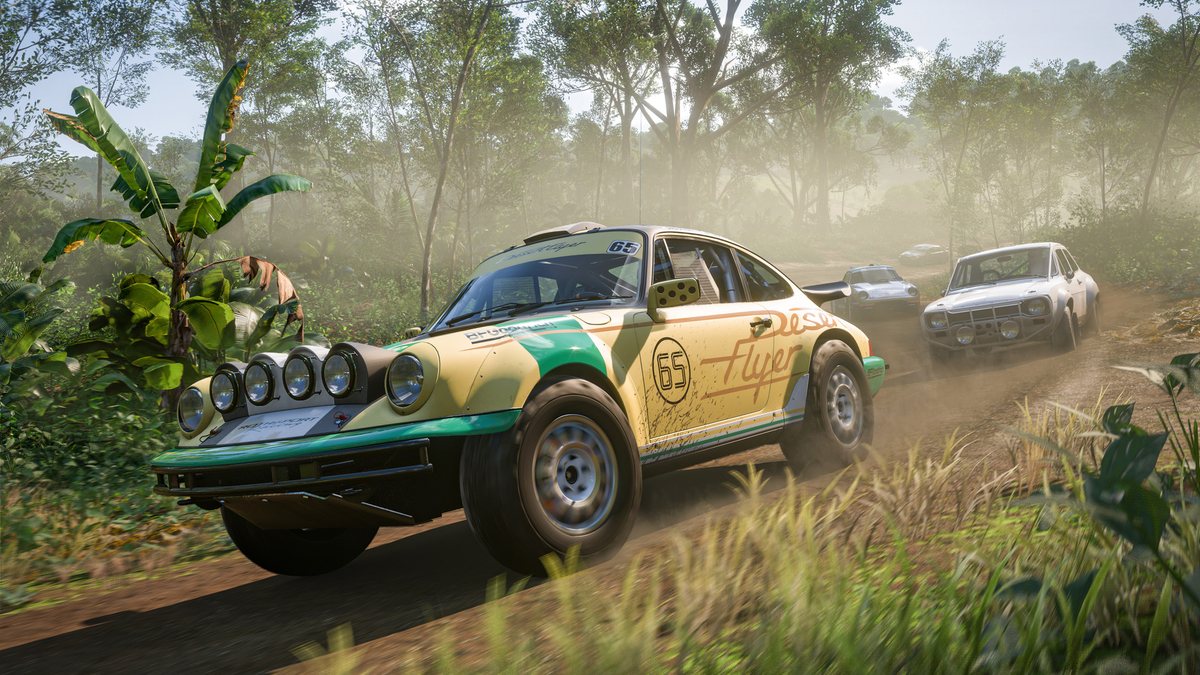 A classic rally car with spotlights slides through a dirt corner in the jungle in Forza Horizon 5