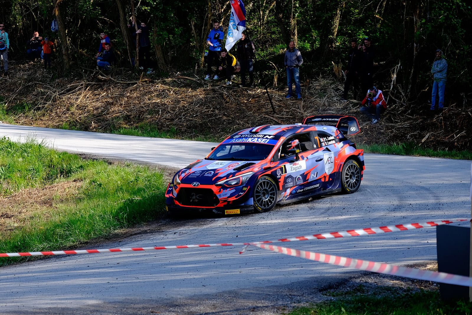 Hyundai i20 Coupe WRC sliding through a tarmac corner in front of spectators at Croatia Rally 2021