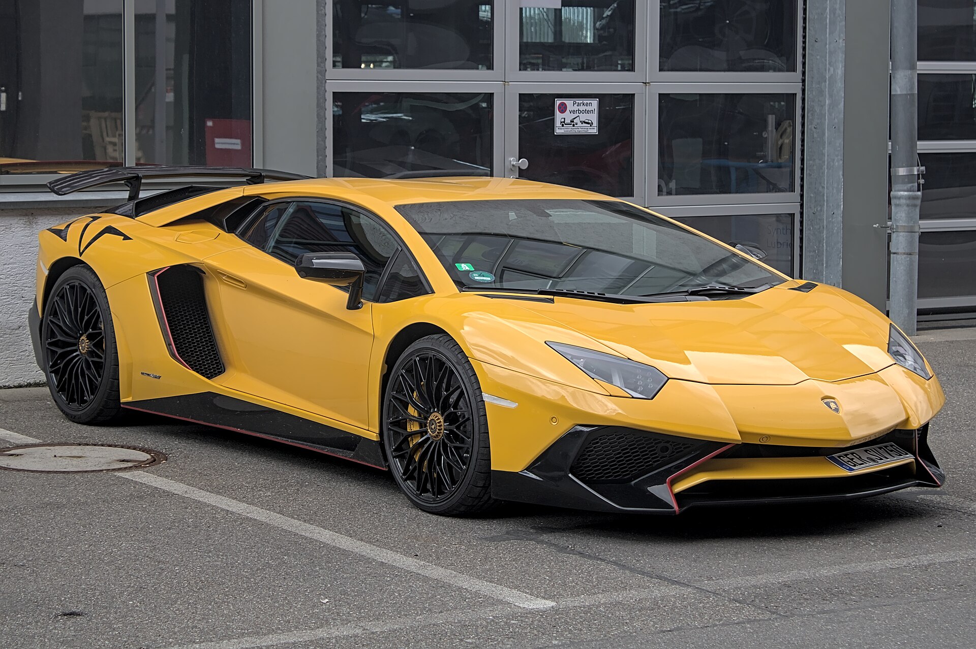 A yellow Lamborghini Aventador SV parked on a street
