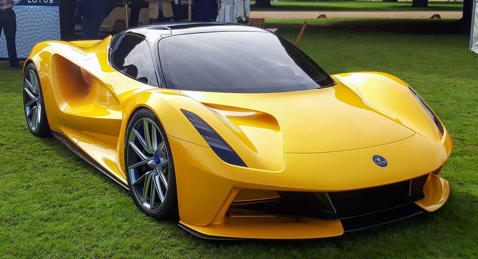 A yellow Lotus Evija on grass