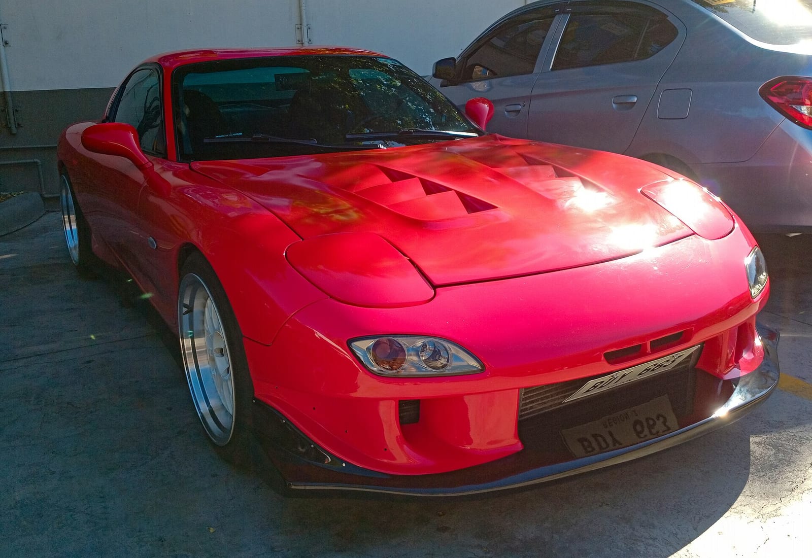 A red Mazda RX-7 FD parked on a street