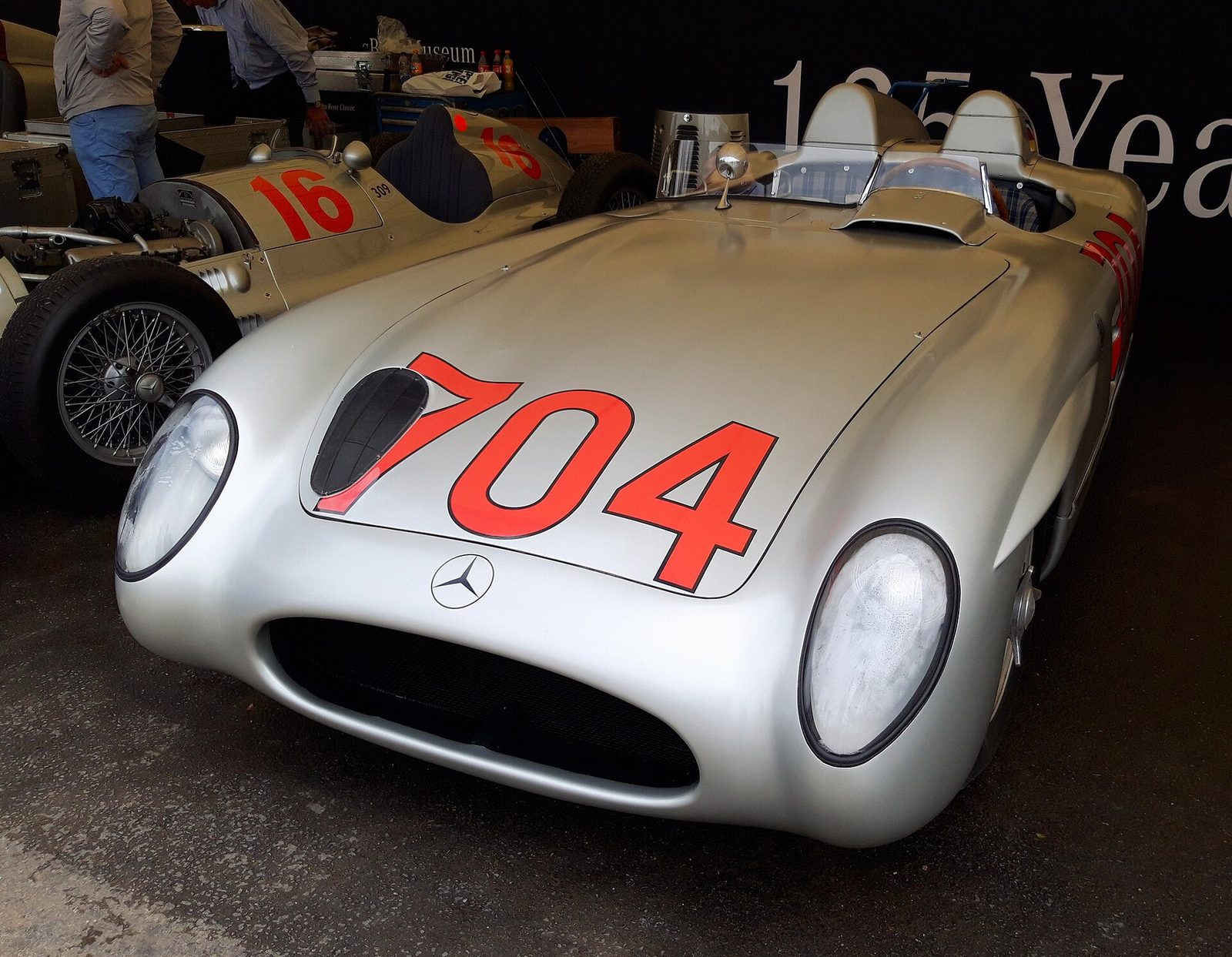 A silver Mercedes-Benz 300 SLR with the number 704 on the bonnet
