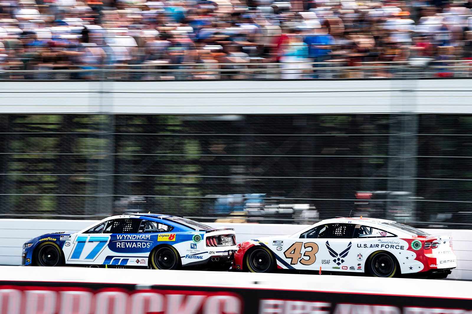 Erik Jones' number 43 Chevrolet behind the number 17 Ford on the straight at Pocono in 2023