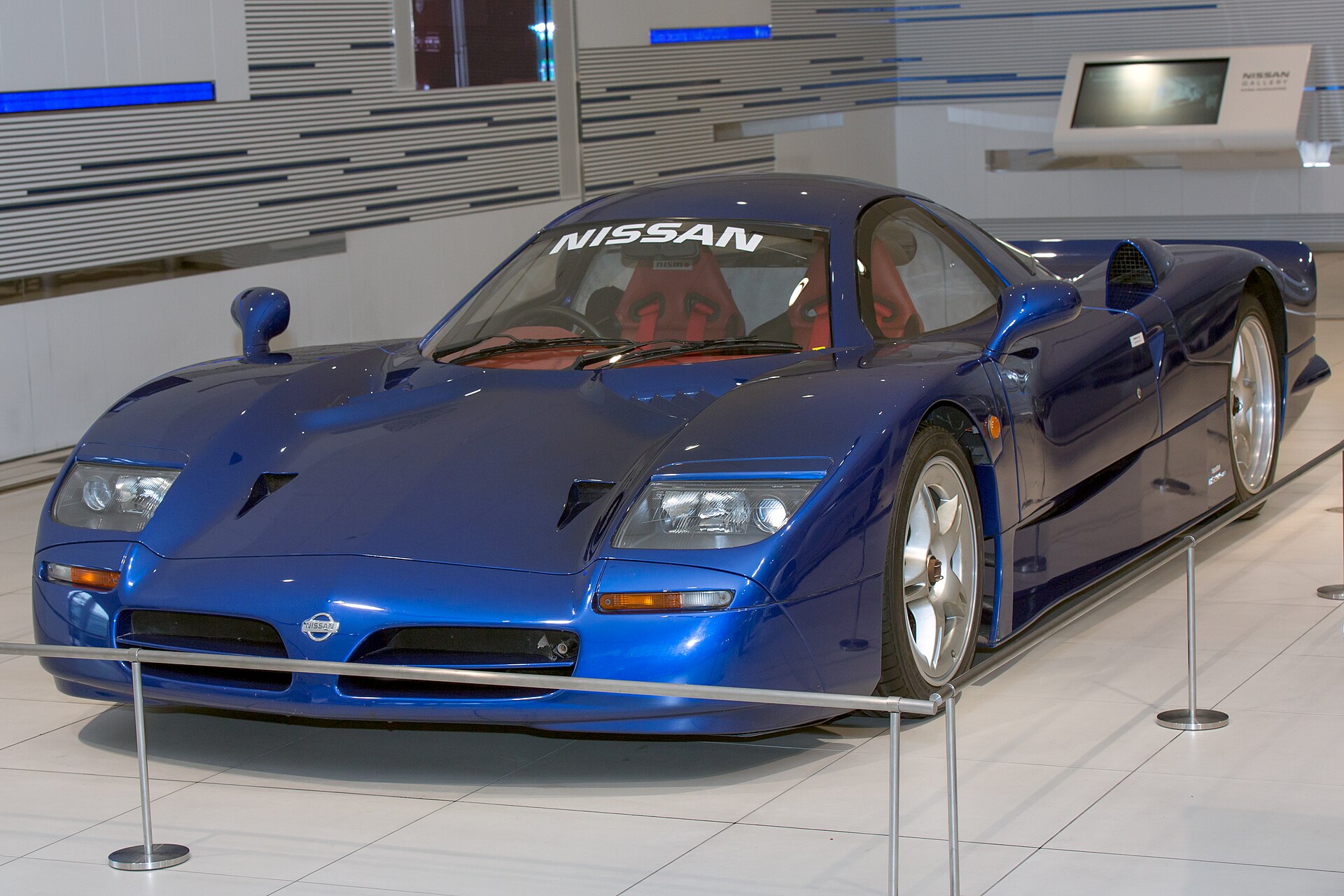 A blue Nissan R390 GT1 road car in a museum