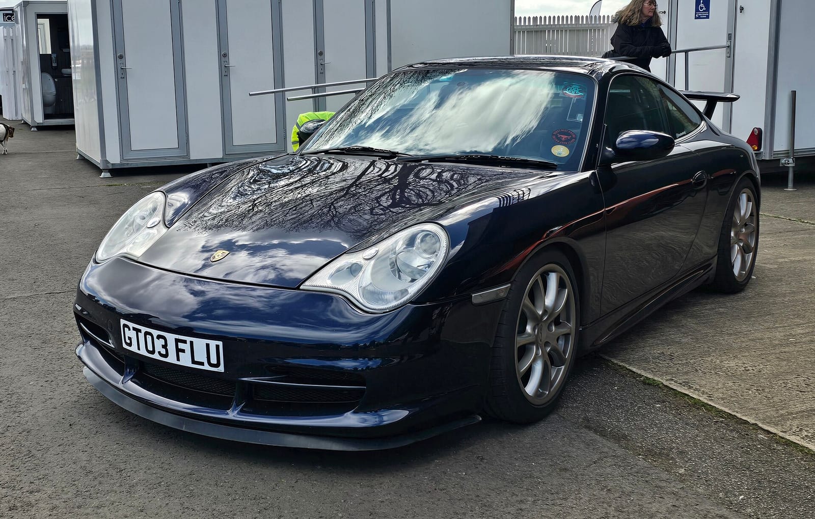 Dark blue Porsche 911 GT3 from the 996 generation parked in a paddock