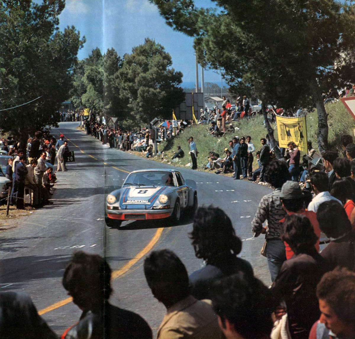 A Martini Porsche 911 Carrera RSR passing crowds on the road at the 1973 Targa Florio