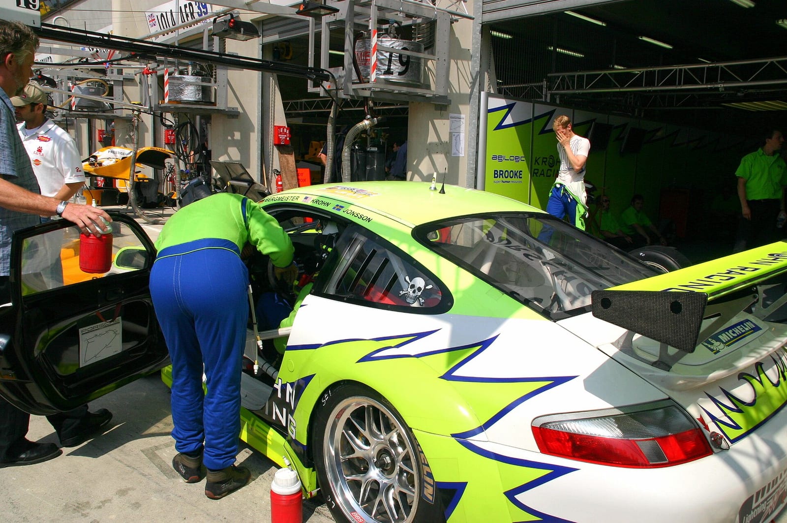 A Porsche 911 GT3 RSR in front of its garage during a pit stop with a driver change