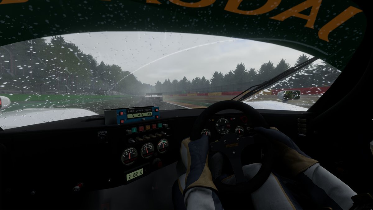 Cockpit view from a prototype in heavy rain in Project Motor Racing, with the driver's hands on the wheel