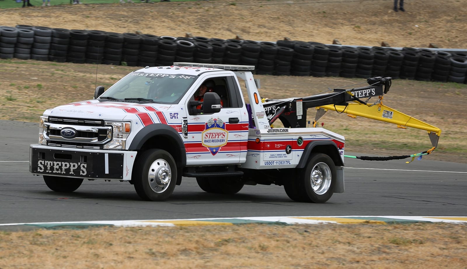 A race recovery tow truck driving on the track at Sonoma Raceway