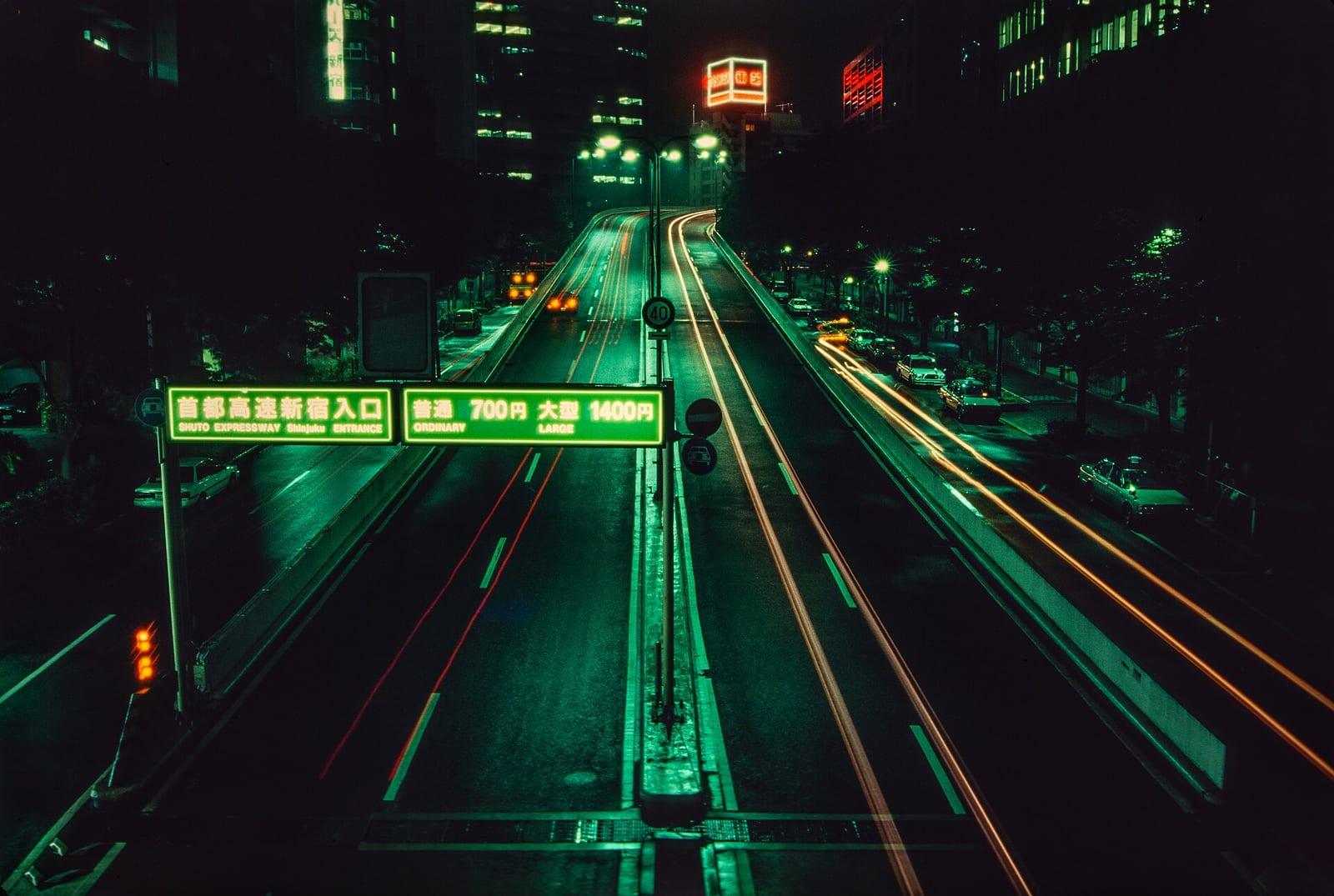 Night view of the Shuto Expressway entrance at Shinjuku in Tokyo with light trails from traffic