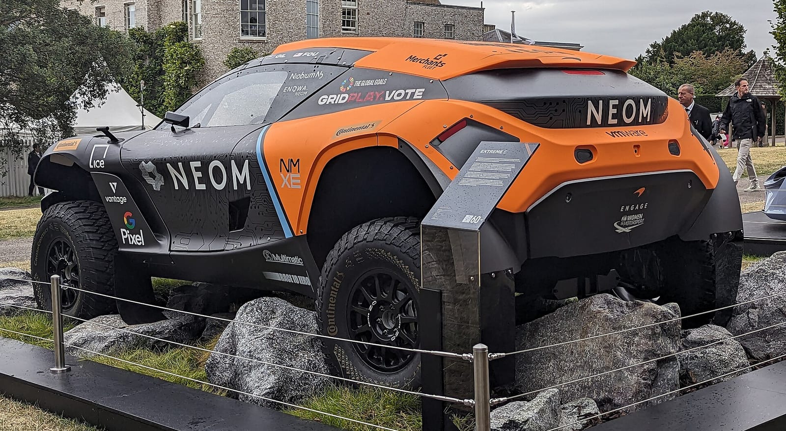 An orange and black McLaren Extreme E Odyssey 21 electric off-road racer on display