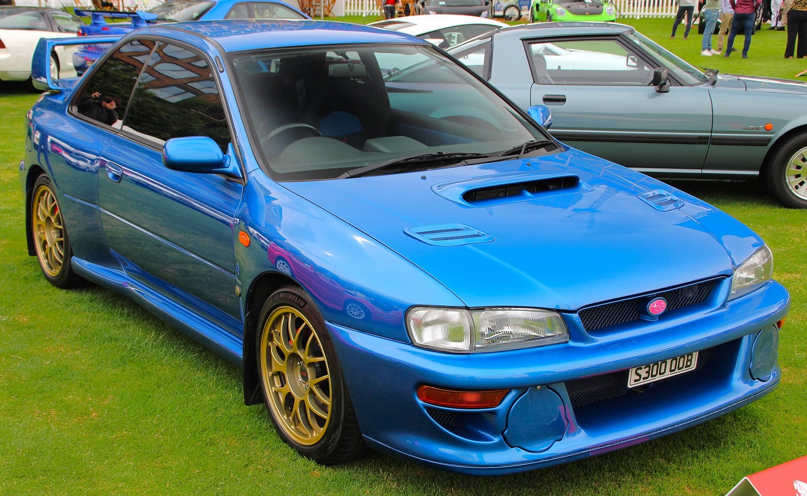 A blue 1998 Subaru Impreza 22B-STi with gold wheels