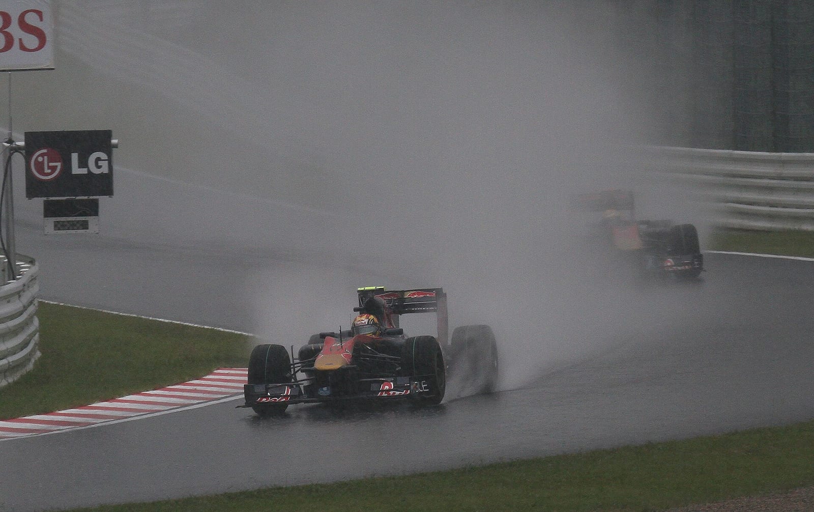 Two Toro Rosso Formula 1 cars in heavy spray at Suzuka in 2010