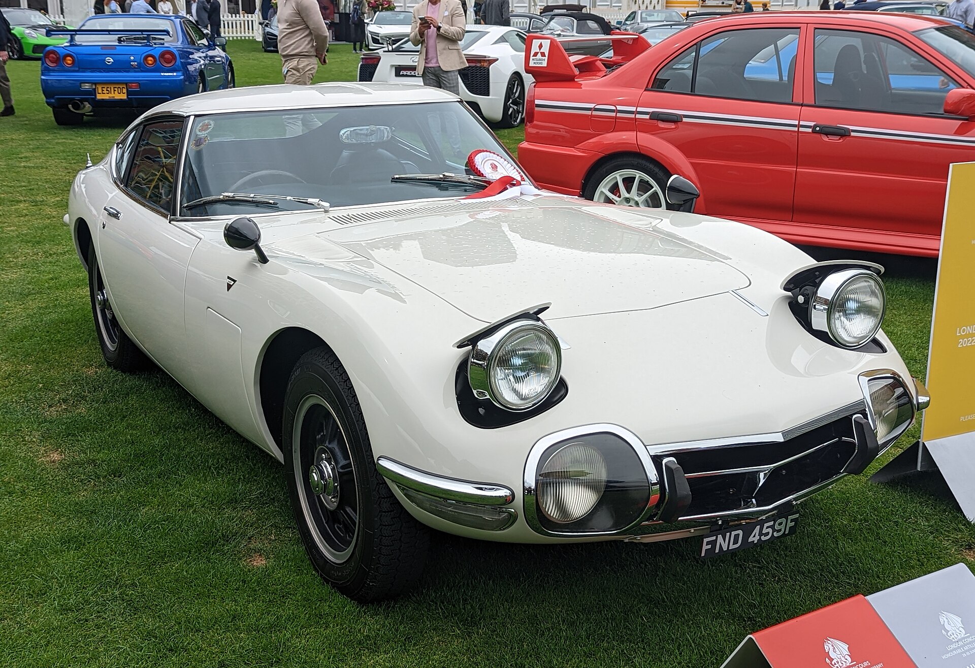 A white Toyota 2000GT parked on grass