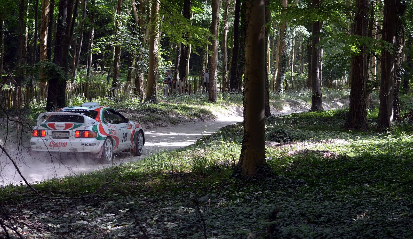 Toyota Celica GT-Four rally car in Castrol colours on a gravel stage in a forest