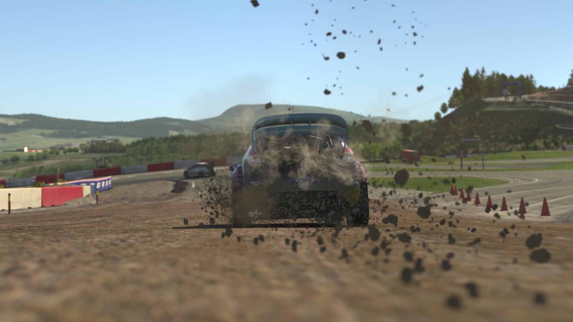 A Ford rallycross car kicks up dirt and stones on a gravel section in iRacing, with a second car ahead and hills behind