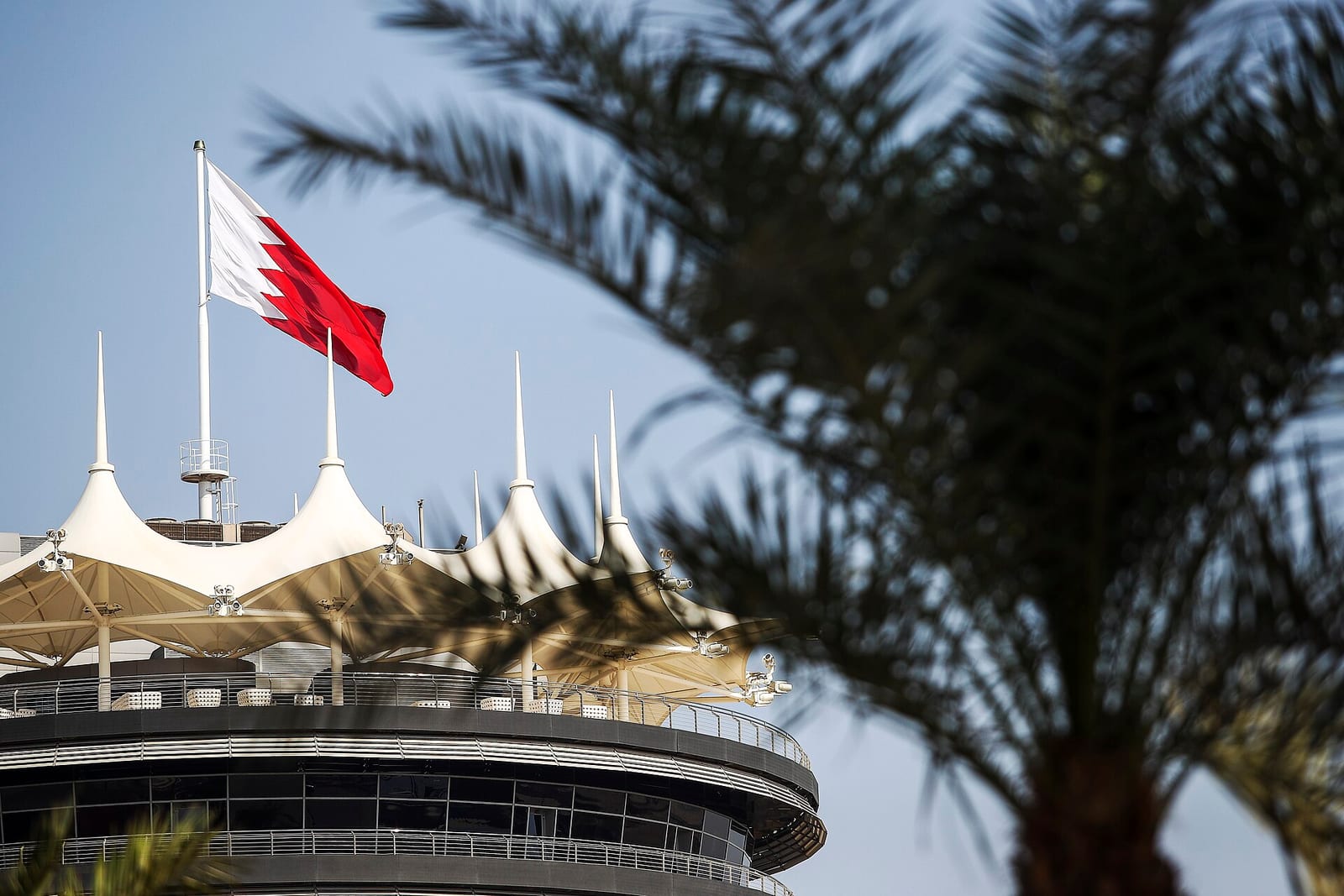 The paddock tower at the Bahrain International Circuit with the flag of Bahrain flying above it