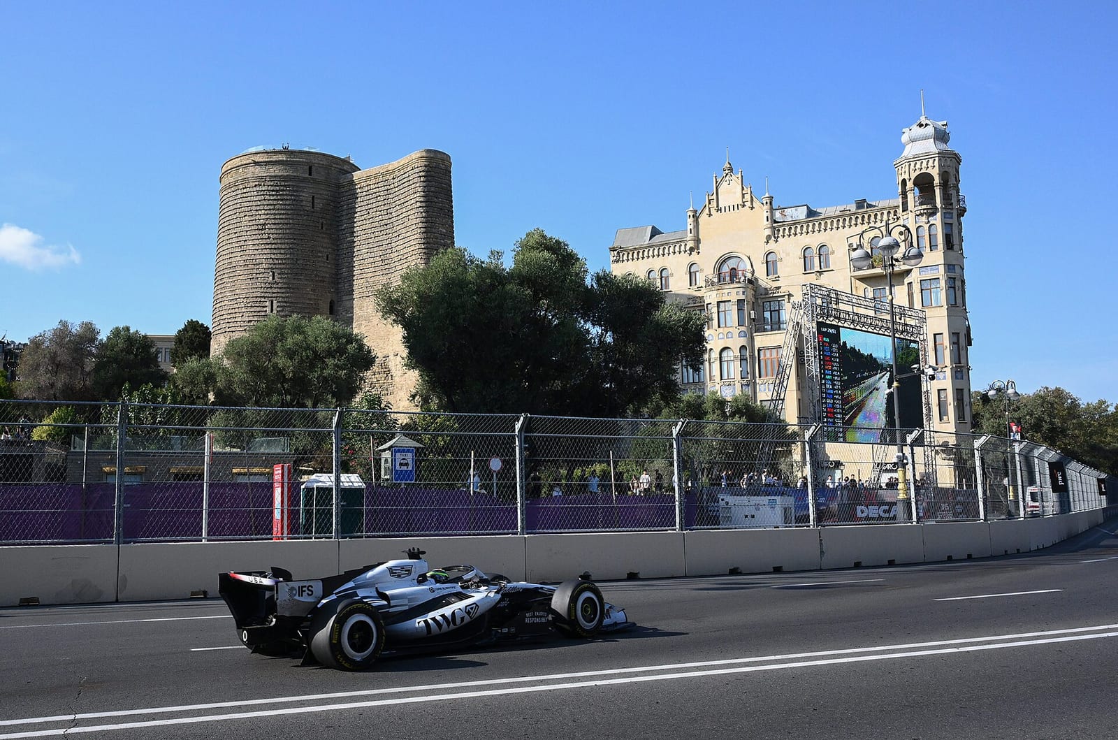 A Formula 1 car passing the Maiden Tower and the old city walls of Baku during the 2026 Azerbaijan Grand Prix
