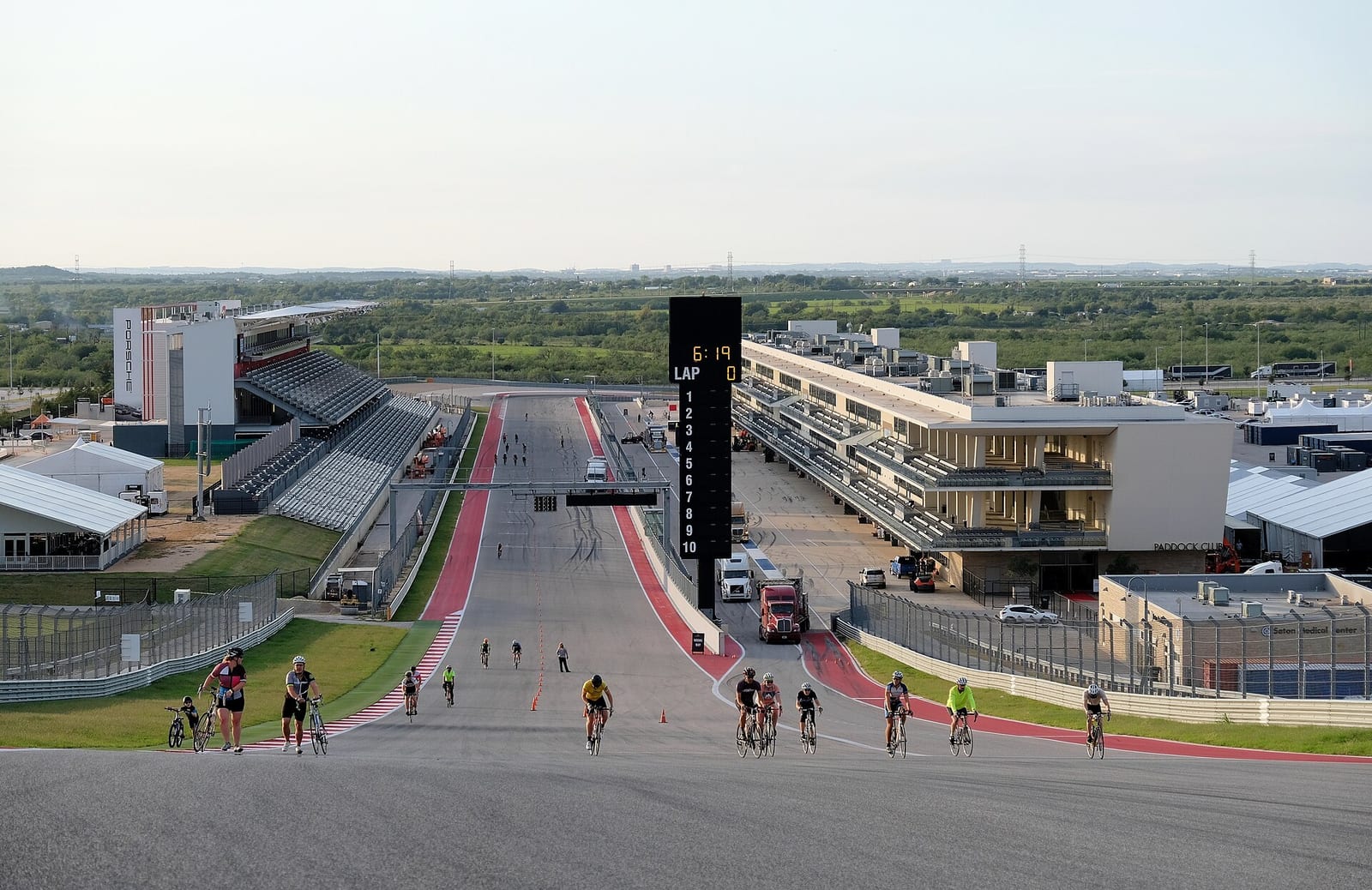 The view from the top of the Turn 1 hill down the main straight at Circuit of the Americas, with the pit building on the right