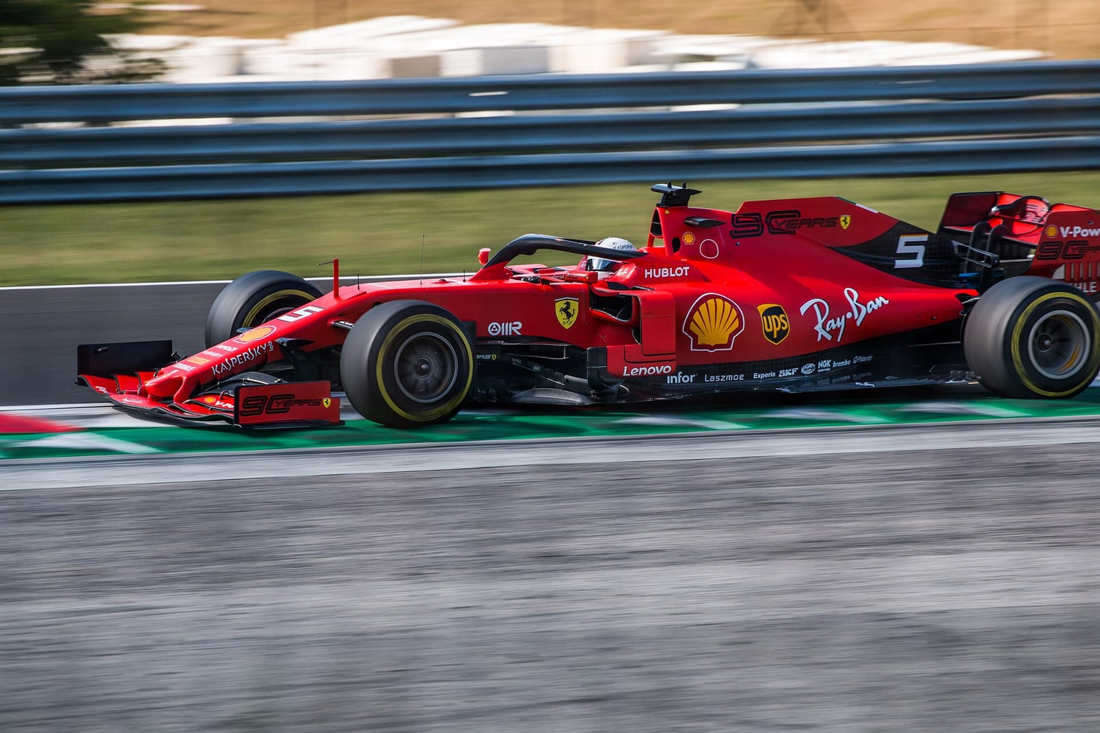 Sebastian Vettel's red Ferrari SF90 side on at speed at the Hungaroring during the 2019 Hungarian Grand Prix weekend