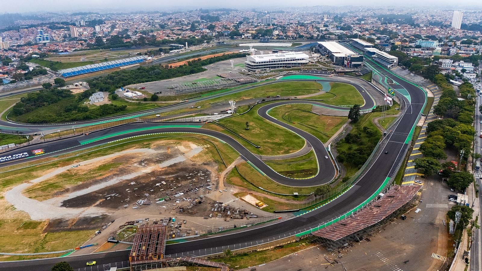 Aerial view of the Interlagos circuit in São Paulo with the pit building, the infield corners and the city behind