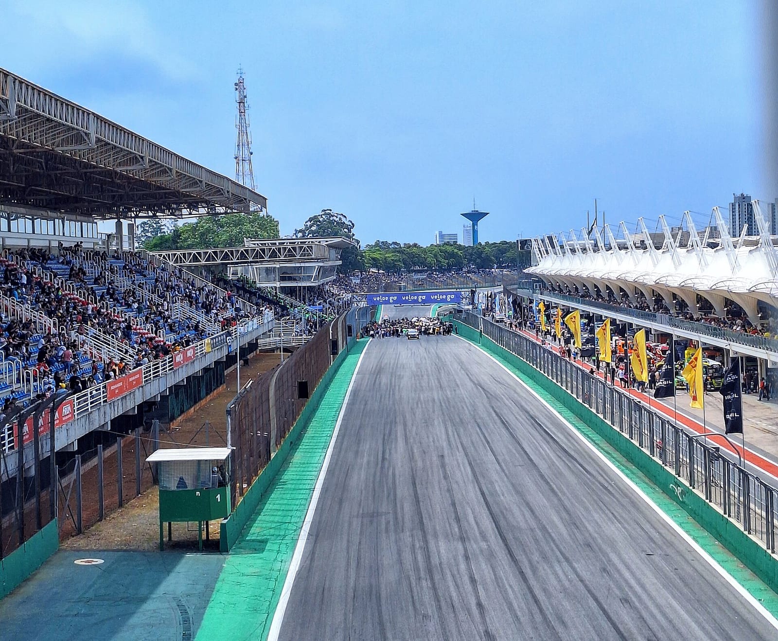 The start and finish straight at Interlagos seen from above the track, with the grandstand on the left and the pit building on the right