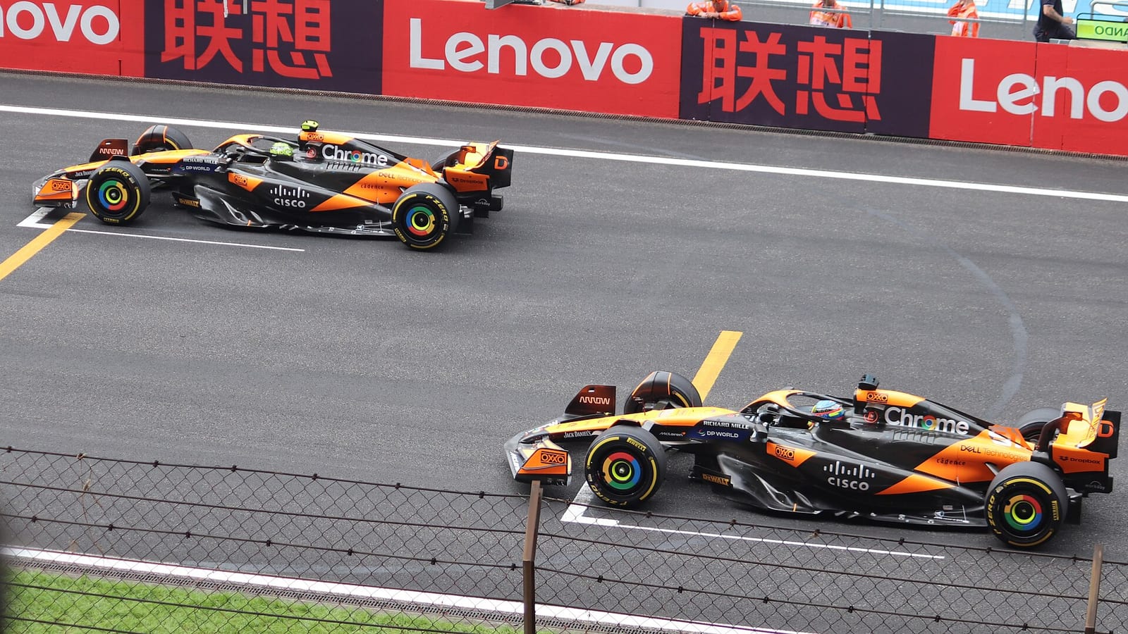 Two papaya and black McLaren MCL38 cars lined up on the starting grid at the 2024 Chinese Grand Prix