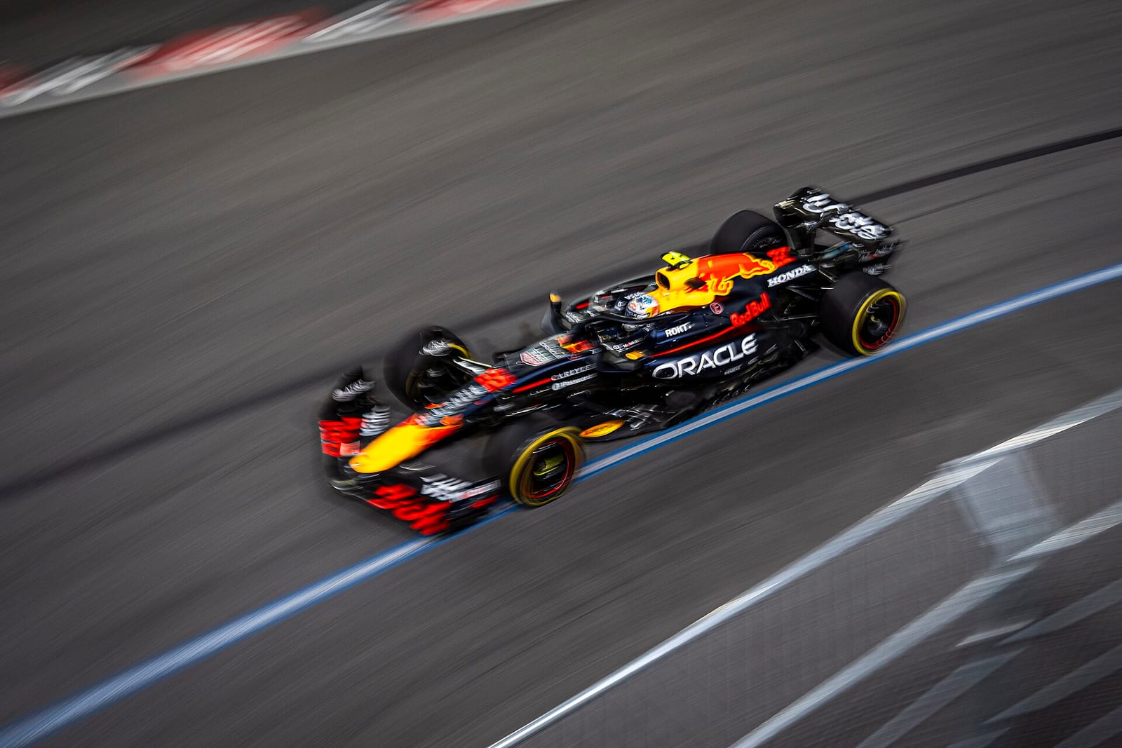 A Red Bull RB21 seen from the side at speed at night at the 2025 Las Vegas Grand Prix, with the background blurred