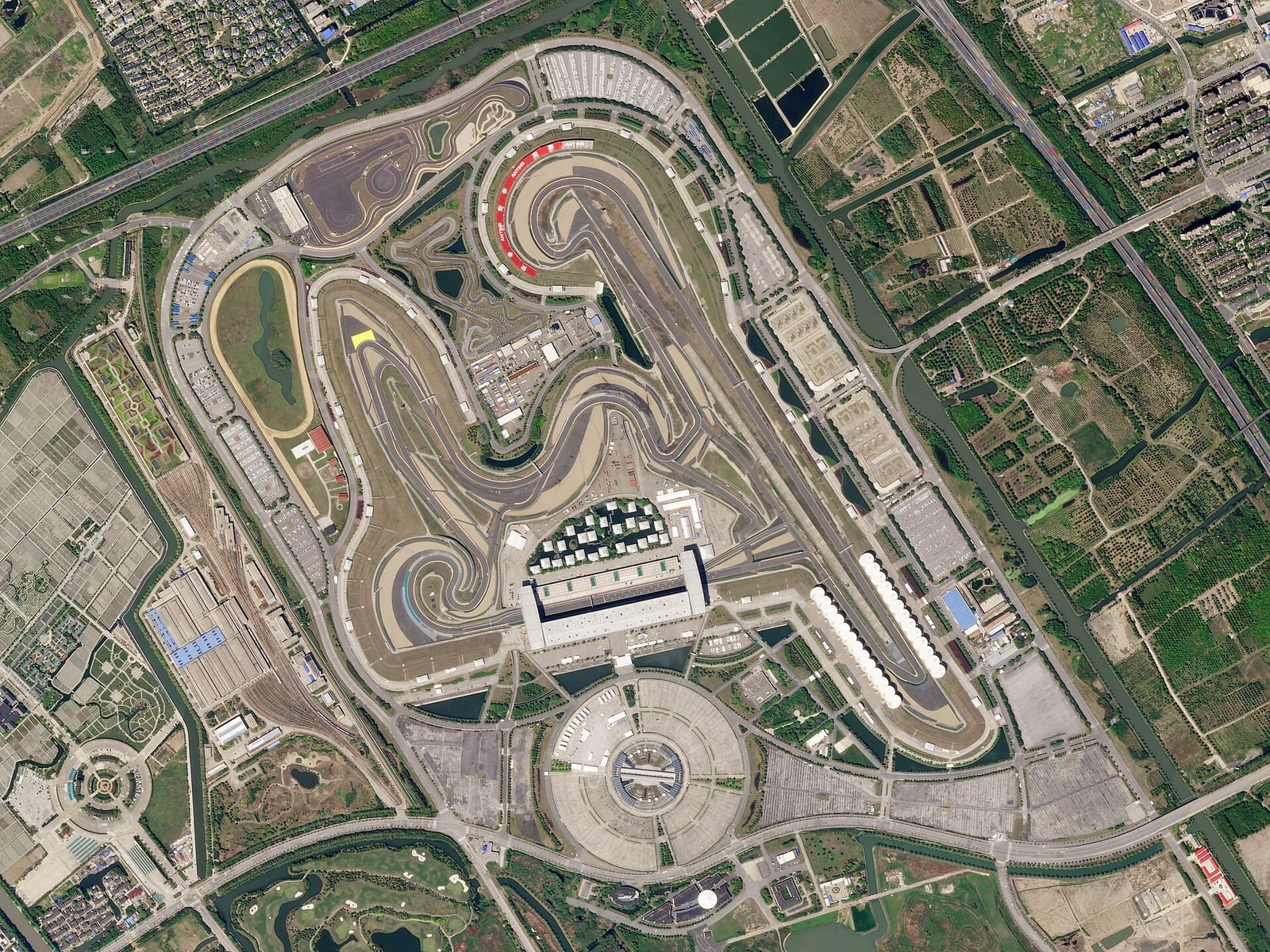 Satellite view of the Shanghai International Circuit showing the spiral of turns 1 and 2 at the top and the long back straight on the right