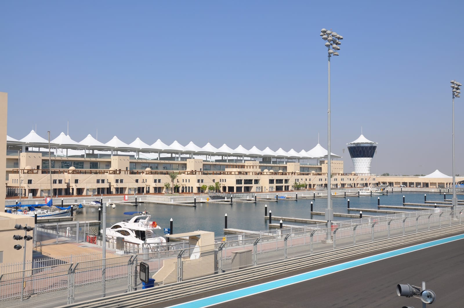 The marina, the pit building with its white tent roofs and the control tower at the Yas Marina Circuit, seen from the edge of the track