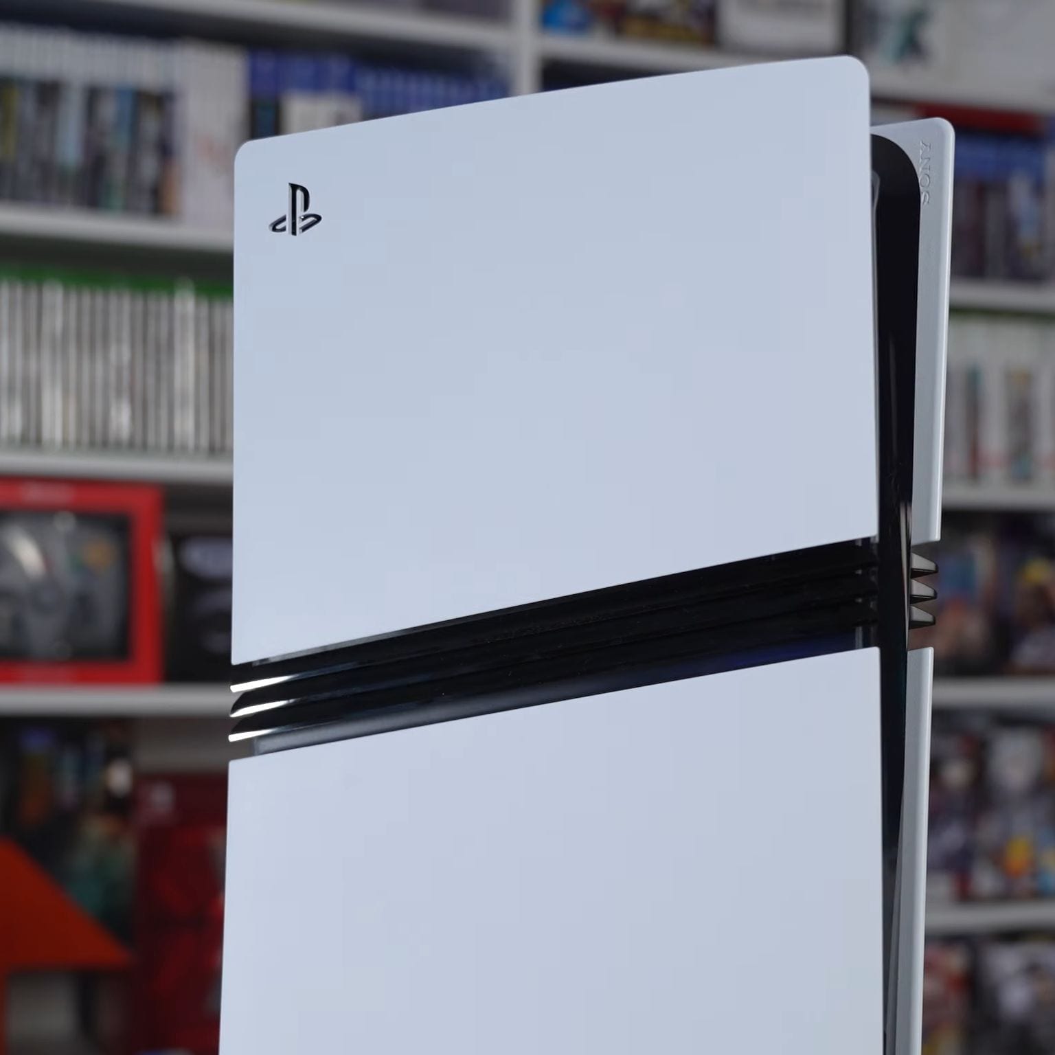 White PlayStation 5 Pro console standing upright, with black stripes across the middle