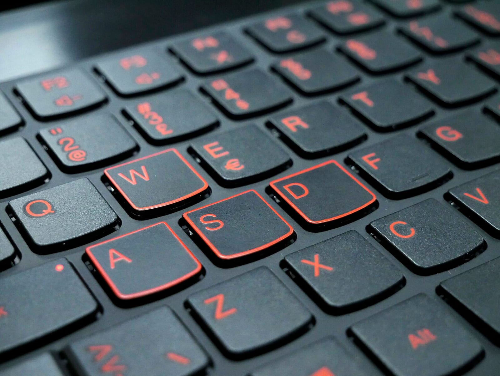 A laptop keyboard with the W, A, S and D keys marked in red