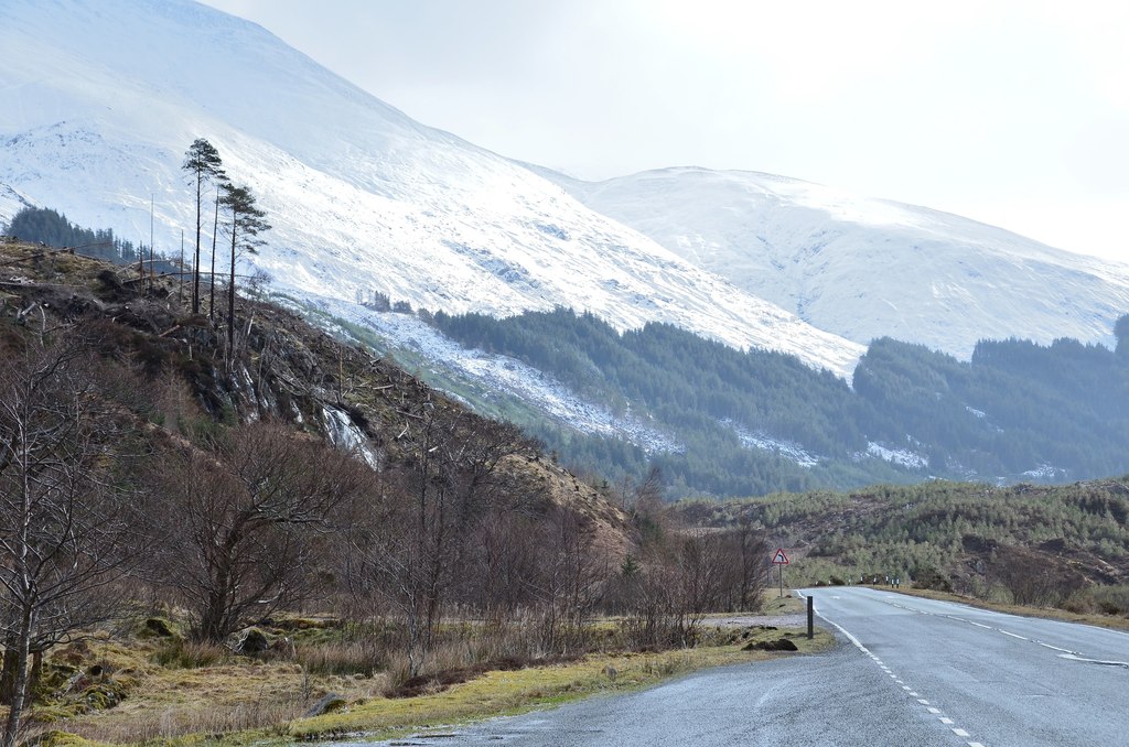 The A87 road through Glen Shiel in the Scottish Highlands with snow on the mountains above