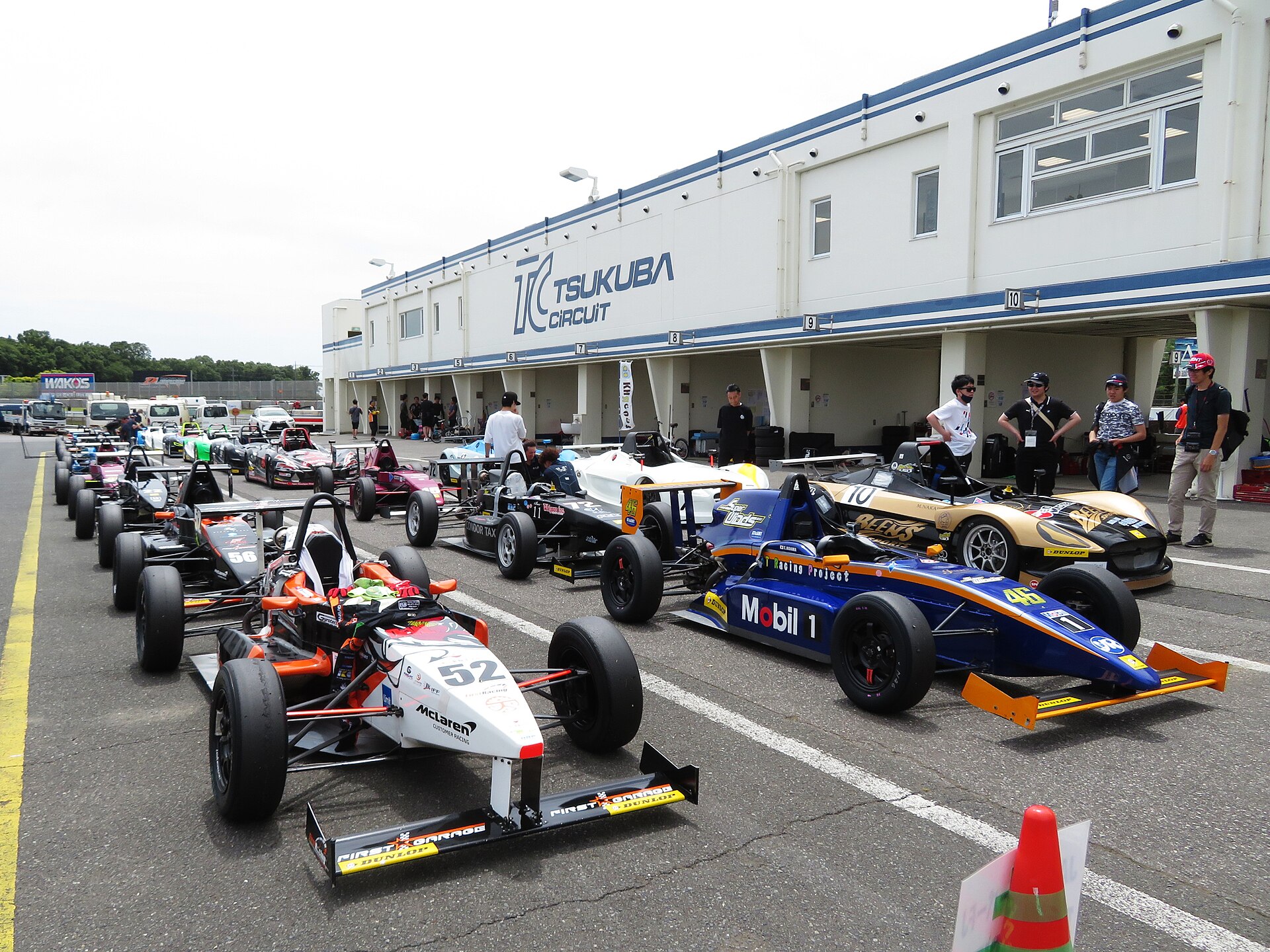 Formula cars lined up in the pit lane at Tsukuba Circuit