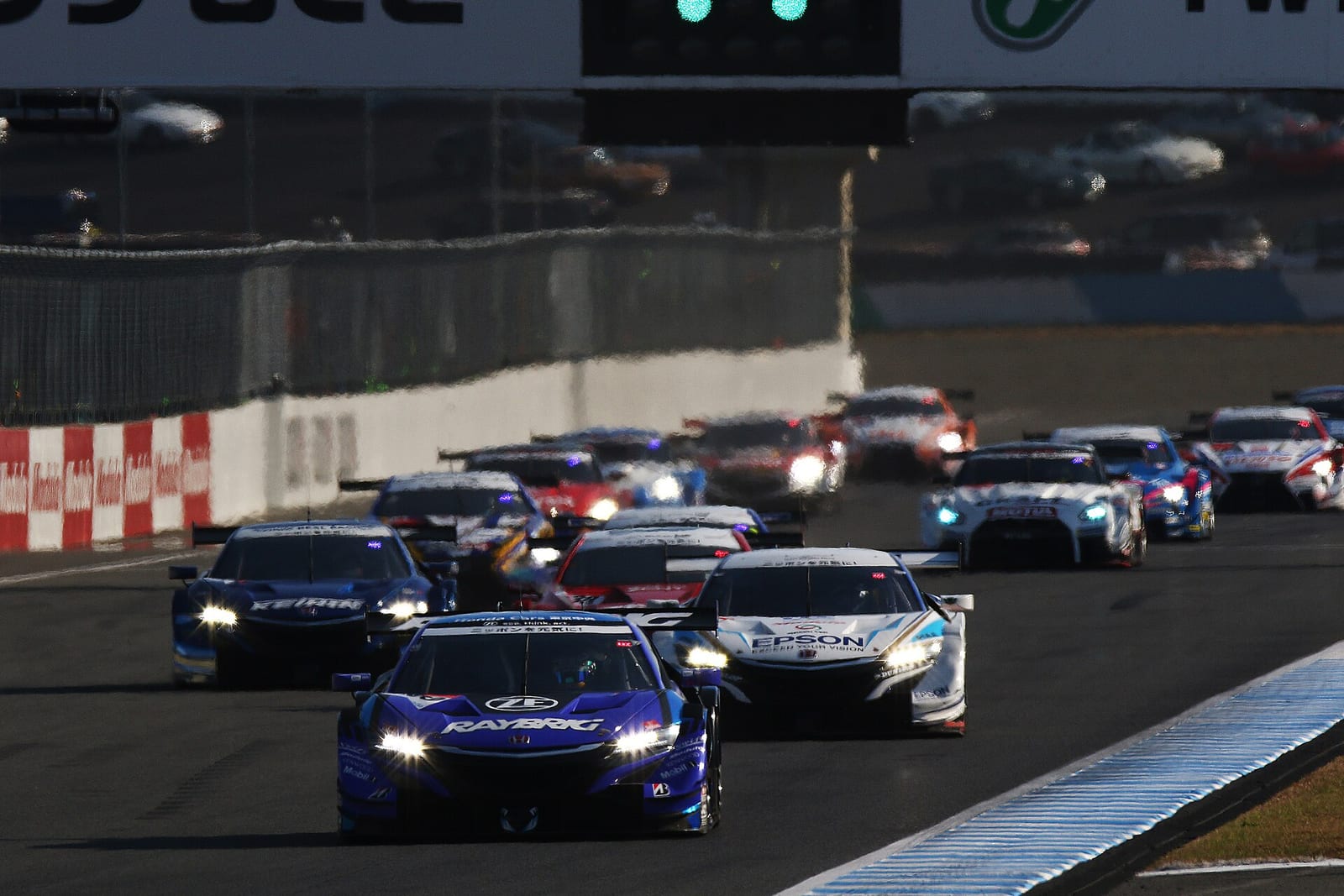 The start of a Super GT race at Twin Ring Motegi with the field arriving at the first corner